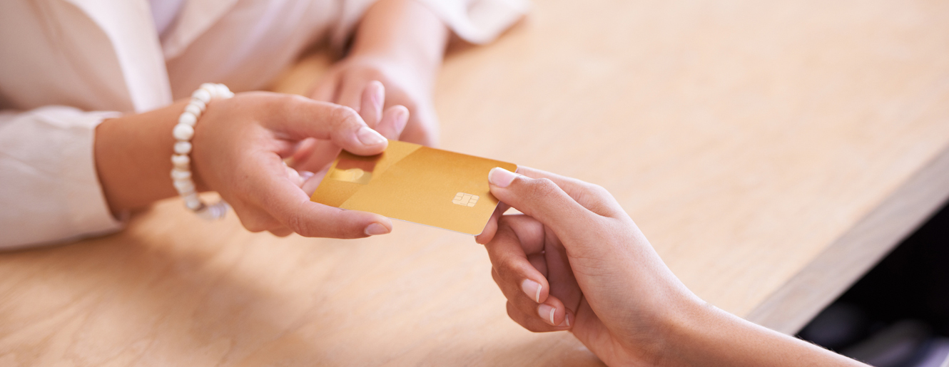 Woman handing credit card to another person.